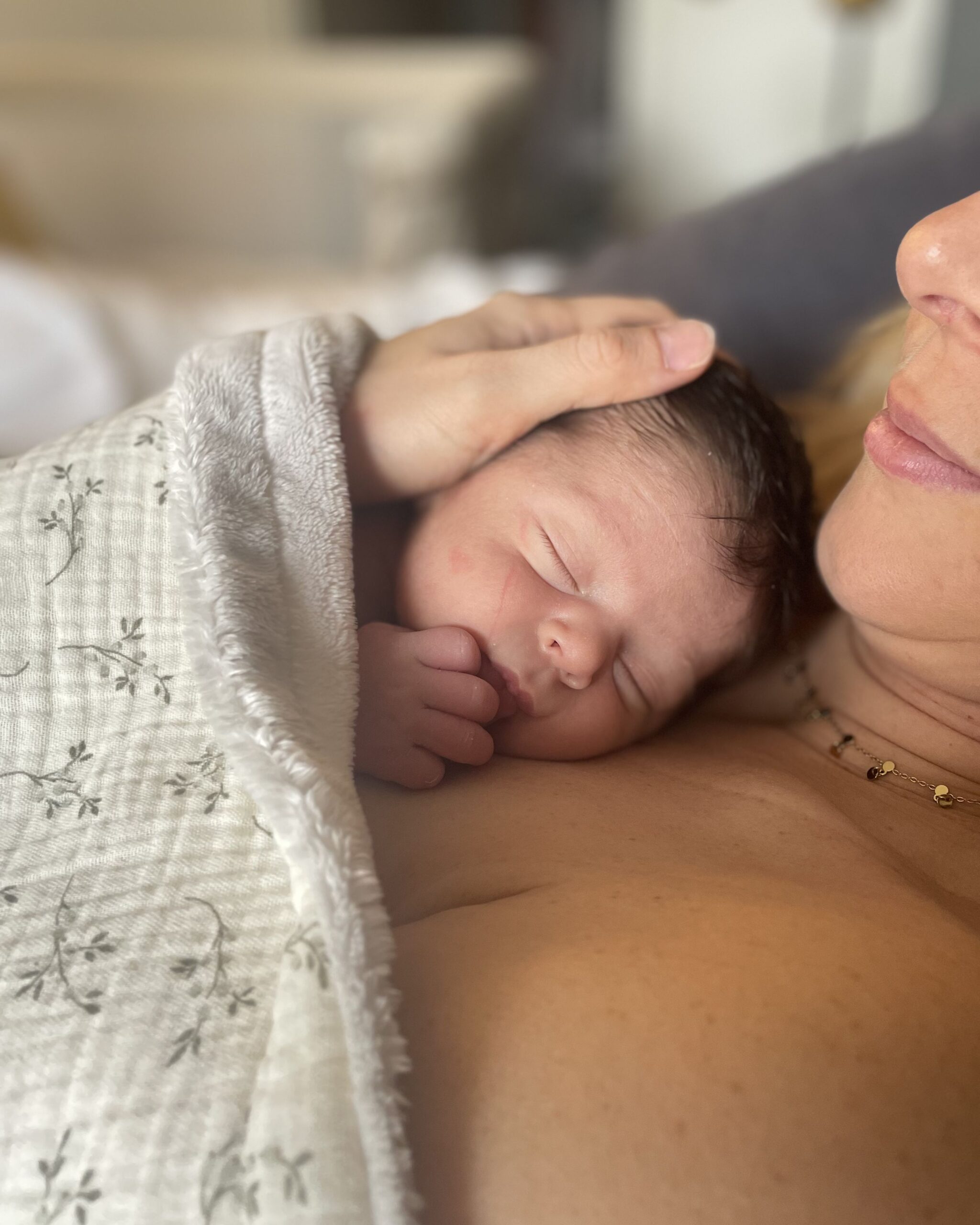 Un bébé en peau à peau avec sa maman après un thérapeutique bain bébé à domicile