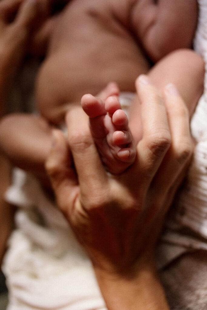 contenance des petits pieds de bébé lors du déshabillage de bébé